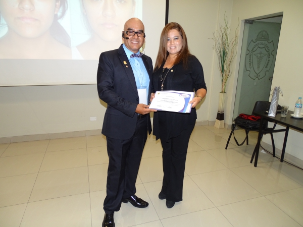 Dr. Elizabeth Oliva entrega su diploma al ponente Dr. Julio Puma. El especialista dictó “Camuflaje ortodóncico de la Clase III quirúrgica”.