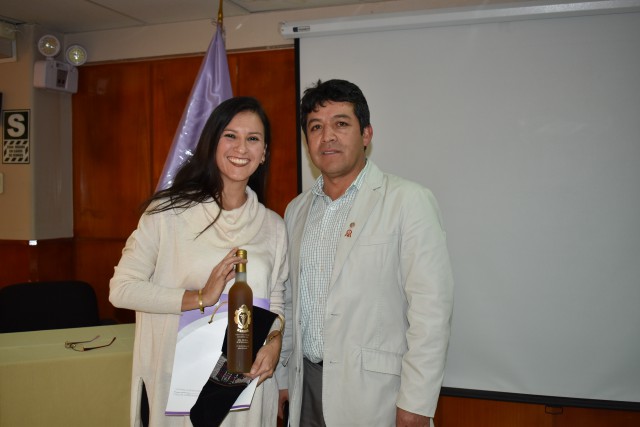 La odontopediatra, Dra. Úrsula Albites, recibe un obsequio del Dr. Wilder Giraldo.